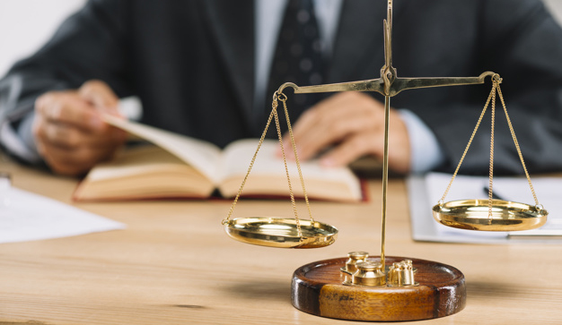 golden-justice-scale-front-lawyer-reading-book-table_23-2147898544
